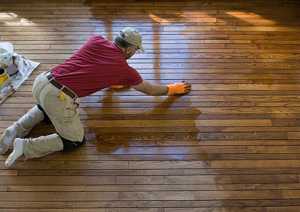 Carpenter staining a hardwood floor | F & A Flooring